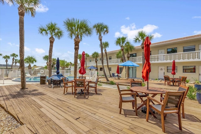 2790 Ocean Shore Blvd Unit 8N, Ormond Beach, FL 32176 - wooden terrace with outdoor dining area and a community pool