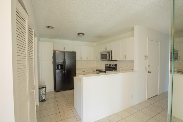 1711 SW 116th Way, Miramar, FL 33025 - kitchen with stainless steel appliances, light tile patterned flooring, white cabinetry, light countertops, and a textured ceiling