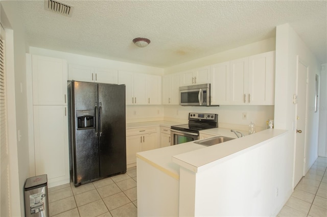1711 SW 116th Way, Miramar, FL 33025 - kitchen featuring appliances with stainless steel finishes, light tile patterned floors, light countertops, a peninsula, and a textured ceiling