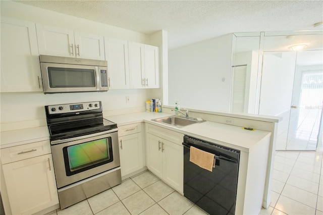 1711 SW 116th Way, Miramar, FL 33025 - kitchen featuring light tile patterned flooring, appliances with stainless steel finishes, a peninsula, light countertops, and a textured ceiling
