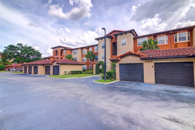 5554 Metrowest Blvd Unit 305, Orlando, FL 32811 - view of front of property featuring a tiled roof, stucco siding, and community garages