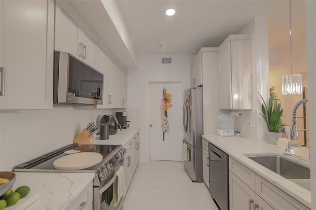 5554 Metrowest Blvd Unit 305, Orlando, FL 32811 - kitchen with stainless steel appliances, tasteful backsplash, light stone counters, white cabinetry, and recessed lighting