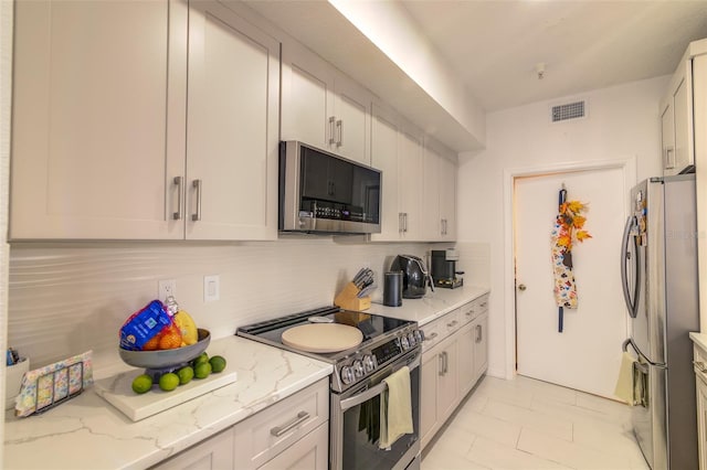 5554 Metrowest Blvd Unit 305, Orlando, FL 32811 - kitchen with appliances with stainless steel finishes, tasteful backsplash, and light stone countertops