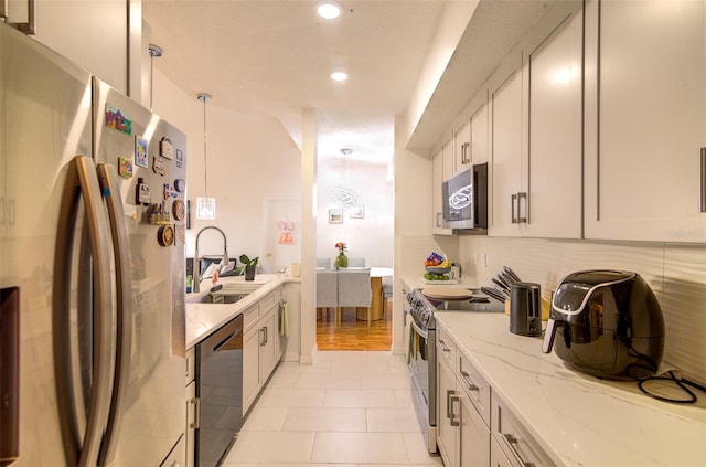 5554 Metrowest Blvd Unit 305, Orlando, FL 32811 - kitchen featuring appliances with stainless steel finishes, light stone countertops, recessed lighting, backsplash, and pendant lighting