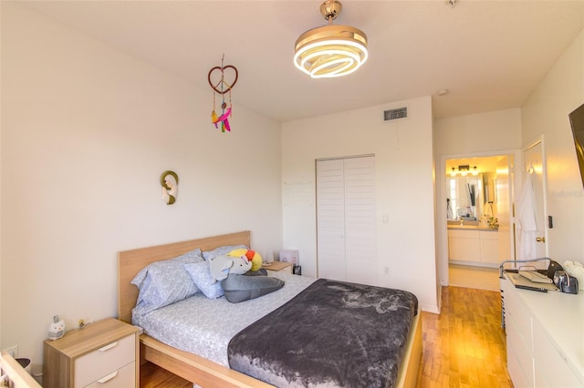 5554 Metrowest Blvd Unit 305, Orlando, FL 32811 - bedroom featuring light wood finished floors, connected bathroom, and a closet