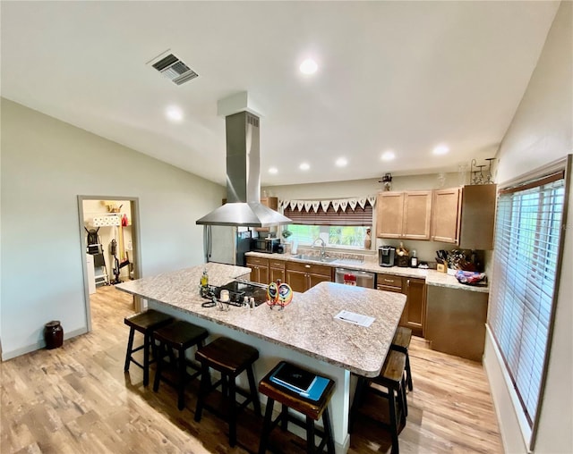 kitchen with light hardwood / wood-style flooring, a breakfast bar, dishwasher, and a center island