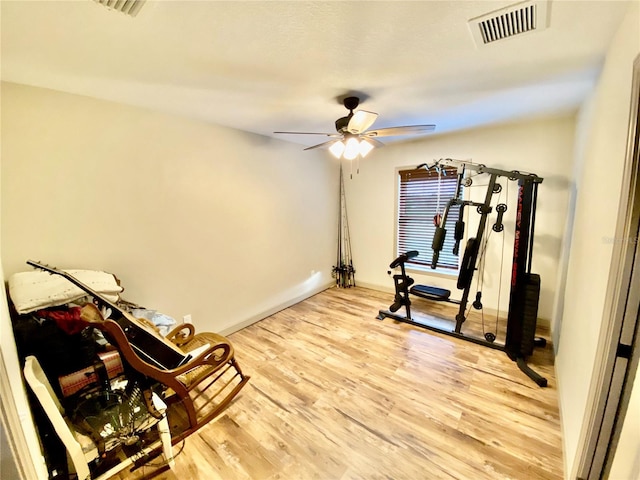 workout room featuring ceiling fan and light wood-type flooring