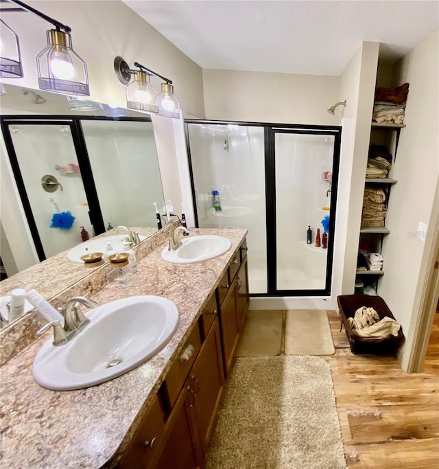 bathroom featuring walk in shower, wood-type flooring, and double vanity