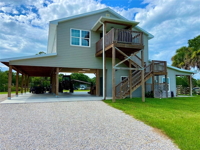 back of house with a lawn, a deck, and a carport