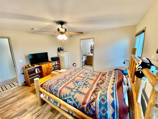 bedroom with ensuite bath, ceiling fan, and light wood-type flooring