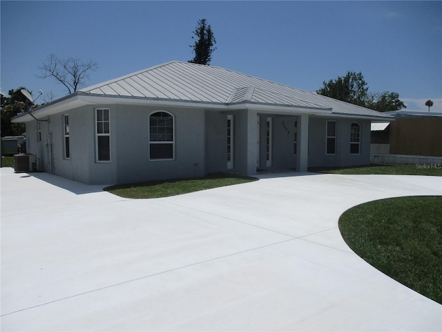 view of front of home with central AC and a front lawn