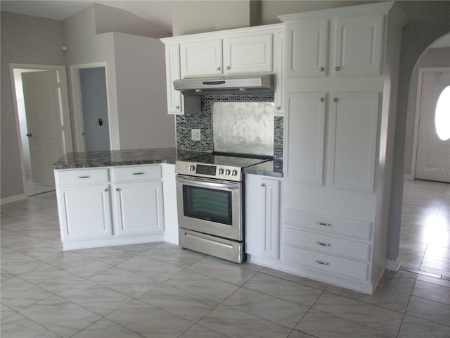 kitchen featuring white cabinetry, stainless steel electric range oven, backsplash, light tile floors, and dark stone countertops