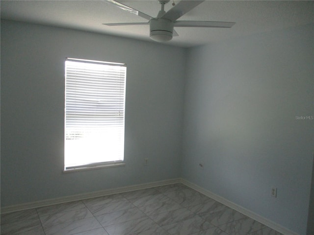 tiled empty room with ceiling fan and a wealth of natural light