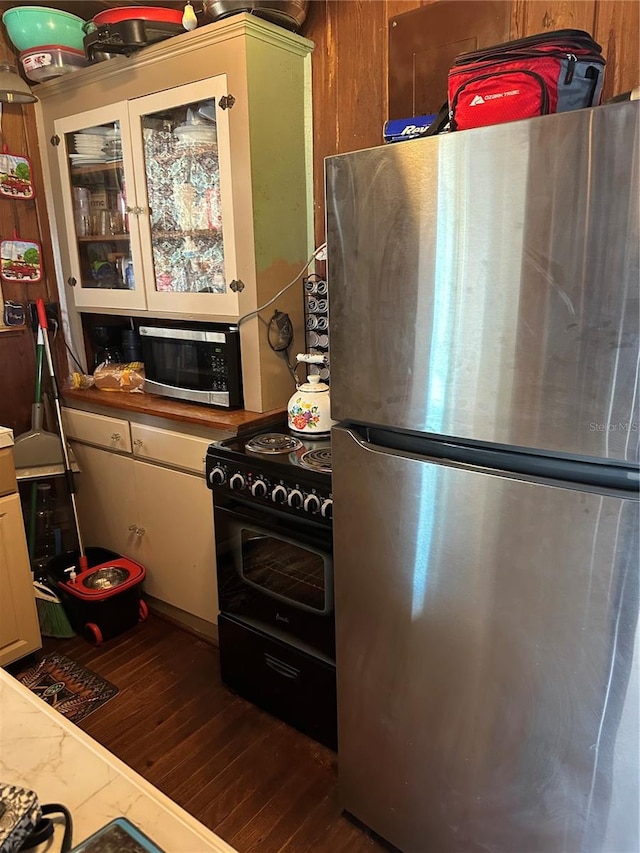 kitchen featuring appliances with stainless steel finishes, dark wood-type flooring, light stone counters, and white cabinets