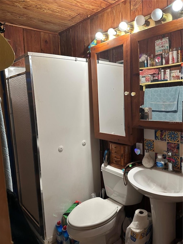 bathroom featuring wood ceiling, wooden walls, toilet, and a shower with shower door