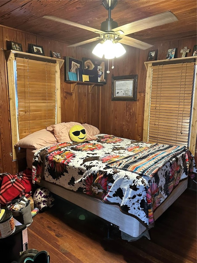 bedroom with ceiling fan, wood walls, wood ceiling, and wood-type flooring