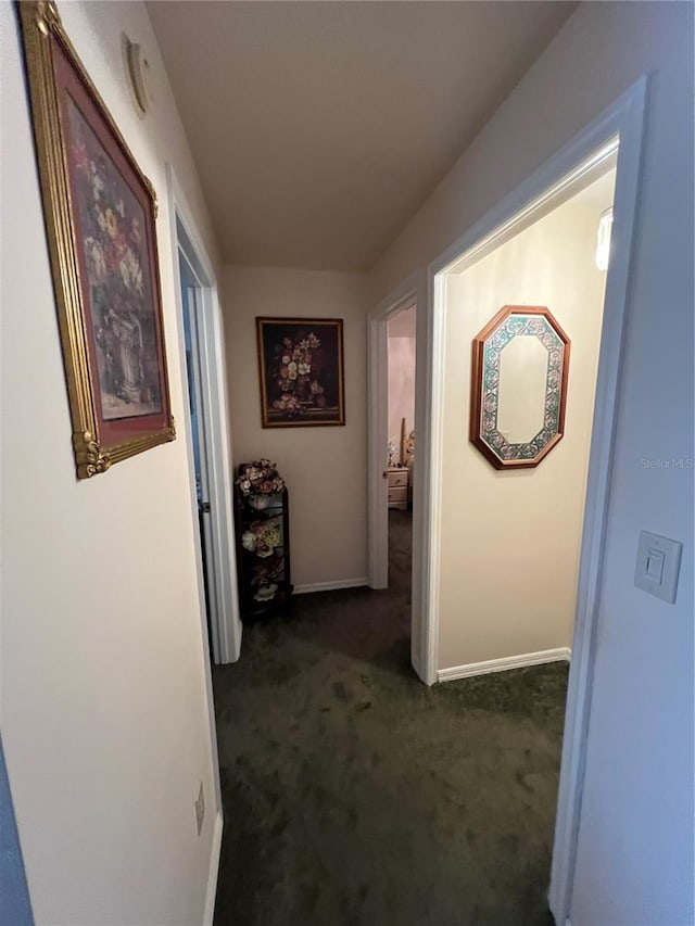 hallway with dark colored carpet