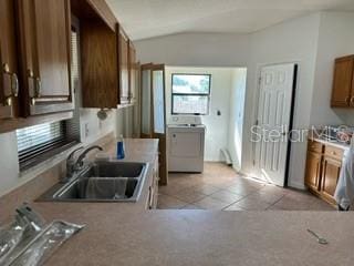 kitchen with sink, lofted ceiling, and light tile floors