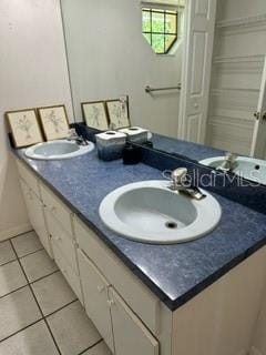 bathroom featuring tile floors and dual vanity