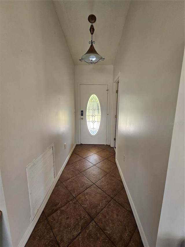 entryway with dark tile floors