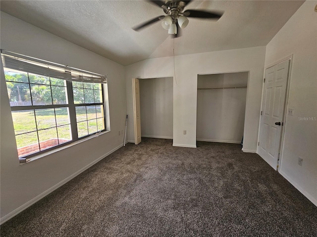 unfurnished bedroom with ceiling fan, dark carpet, and a textured ceiling