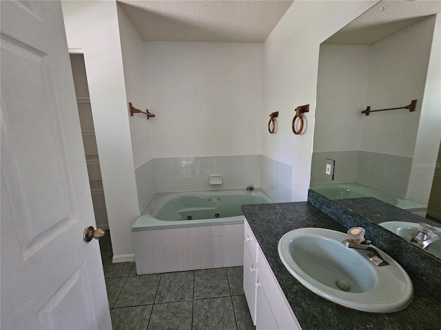 bathroom with a relaxing tiled bath, tile flooring, a textured ceiling, and large vanity