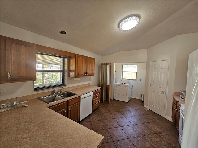 kitchen featuring white appliances, washer / clothes dryer, sink, dark tile flooring, and lofted ceiling