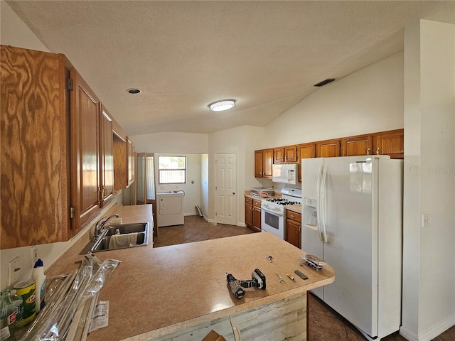 kitchen featuring sink, white appliances, light tile flooring, washer / dryer, and vaulted ceiling