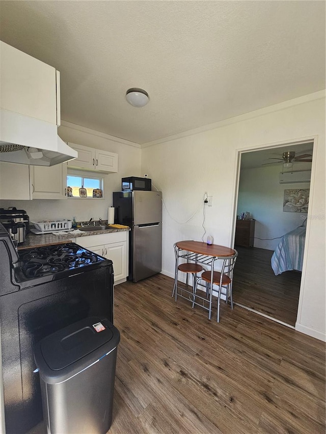 kitchen with exhaust hood, ceiling fan, stainless steel refrigerator, white cabinetry, and dark wood-type flooring