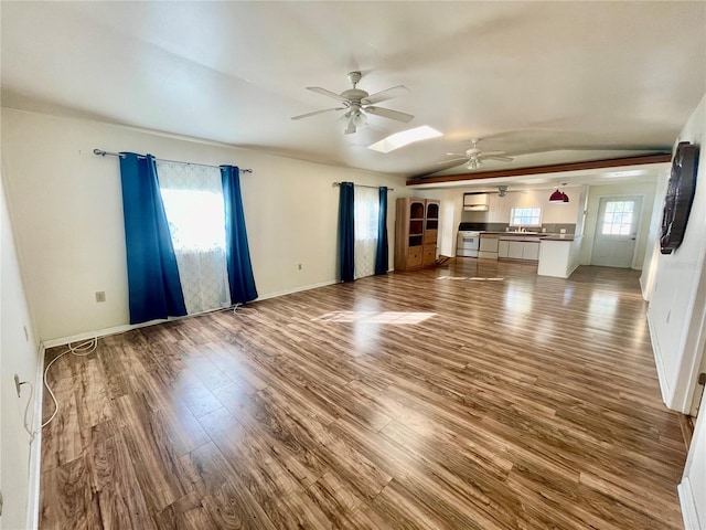 unfurnished living room with a healthy amount of sunlight, ceiling fan, and hardwood / wood-style floors