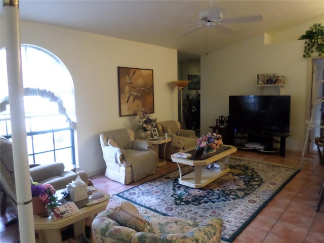 living room with vaulted ceiling, a wealth of natural light, tile patterned floors, and ceiling fan