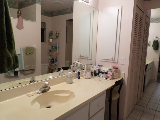 bathroom with vanity, tile patterned floors, and toilet