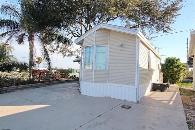 view of side of property featuring central air condition unit and a patio