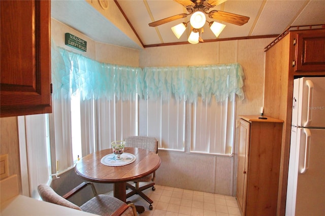 dining room featuring lofted ceiling, light tile floors, and ceiling fan