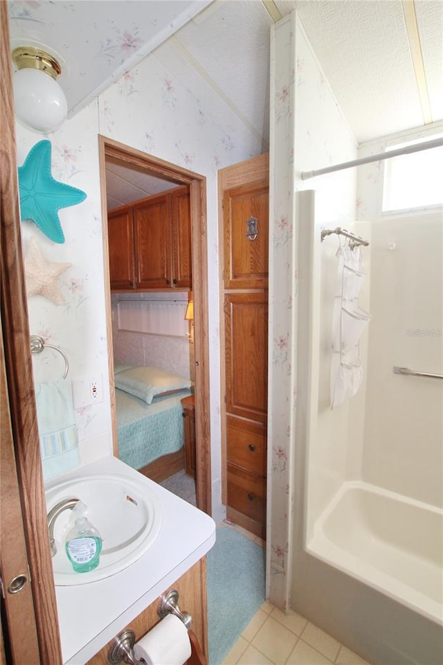 bathroom featuring vanity, backsplash, bathing tub / shower combination, tile floors, and a textured ceiling