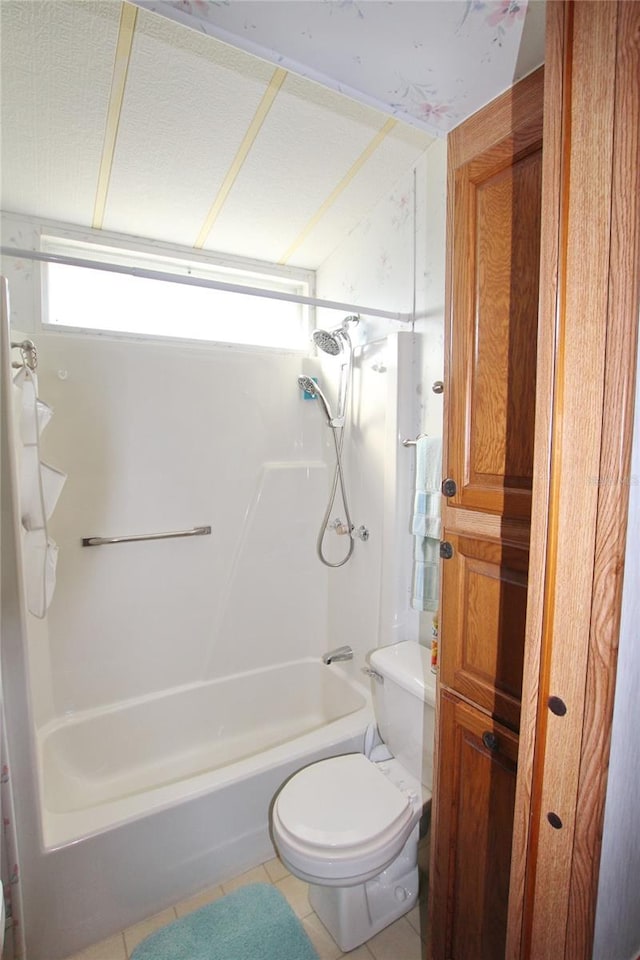 bathroom with tile floors, bathtub / shower combination, and toilet