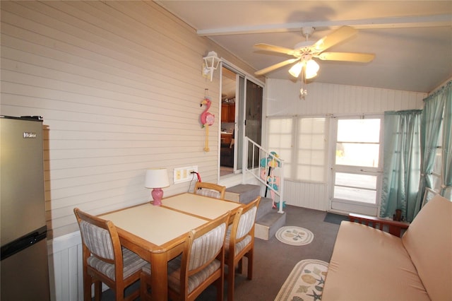 dining area with dark carpet, ceiling fan, and vaulted ceiling