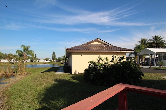 view of property exterior featuring a gazebo, a water view, and a lawn