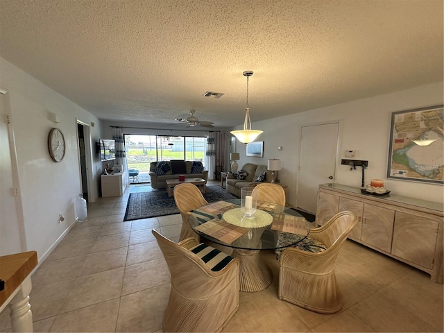 dining space featuring light tile floors, ceiling fan, and a textured ceiling