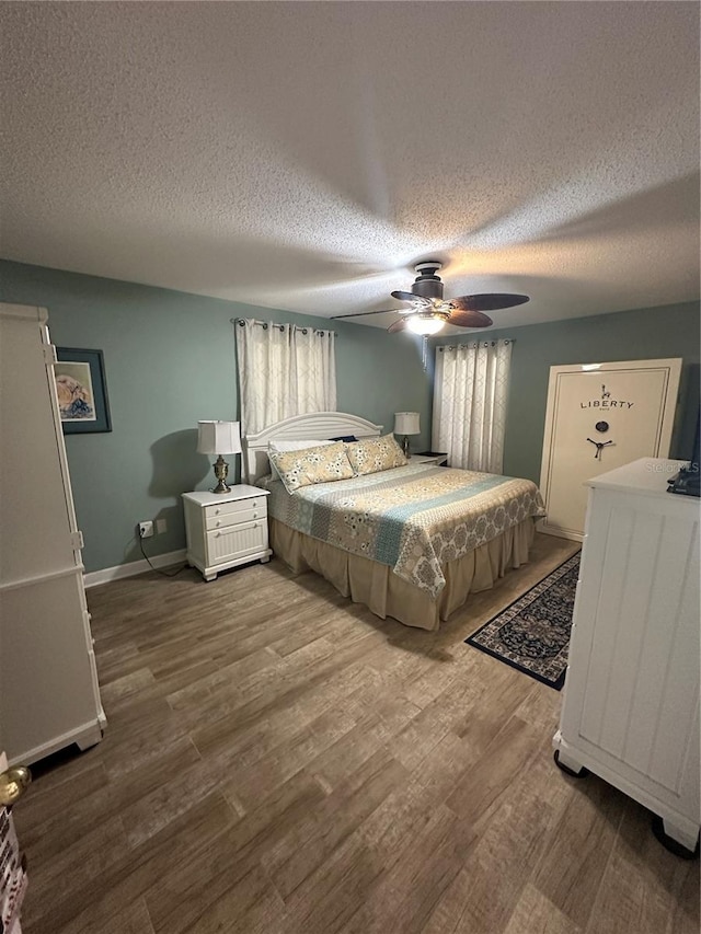 bedroom featuring a textured ceiling, ceiling fan, and wood-type flooring