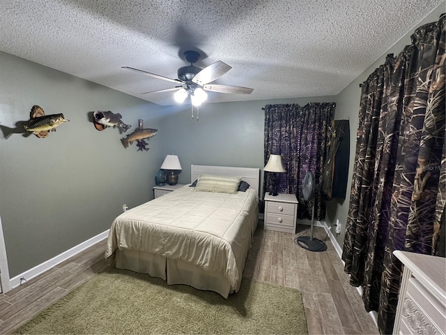 bedroom with hardwood / wood-style floors, a textured ceiling, and ceiling fan