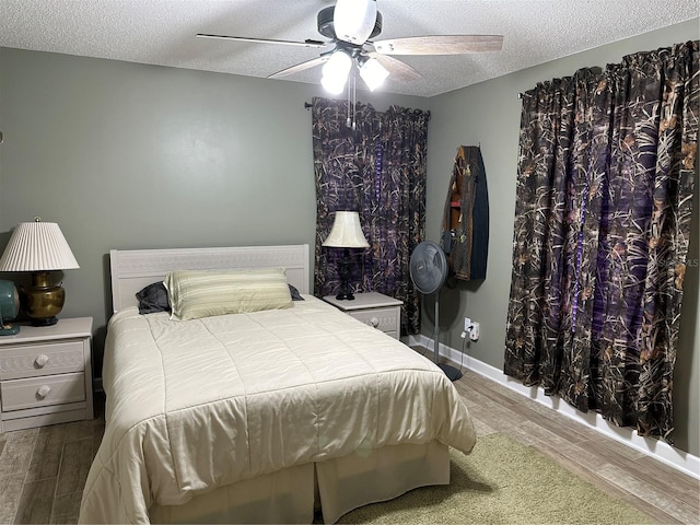 bedroom with a textured ceiling, wood-type flooring, and ceiling fan