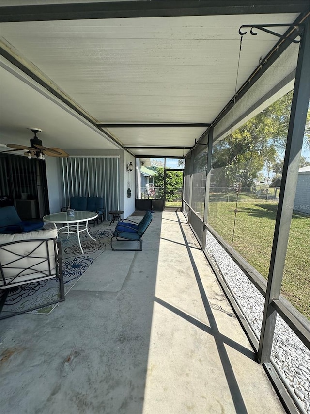 unfurnished sunroom featuring ceiling fan