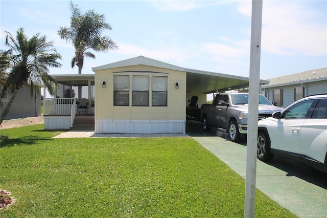 view of front of property featuring a front yard and a carport