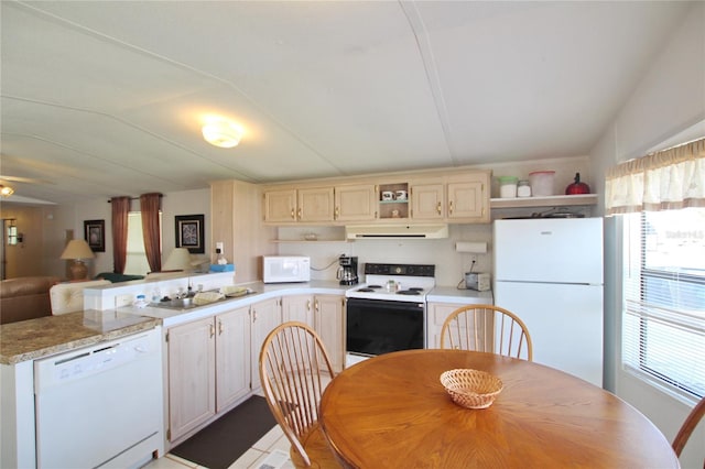 kitchen featuring a healthy amount of sunlight, light tile floors, white appliances, and sink