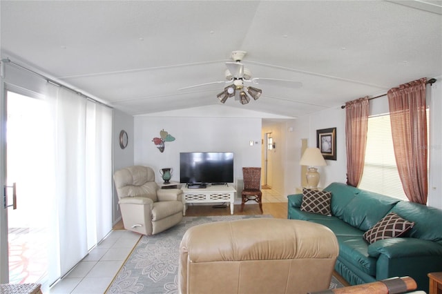 living room with ceiling fan, lofted ceiling, and light tile floors