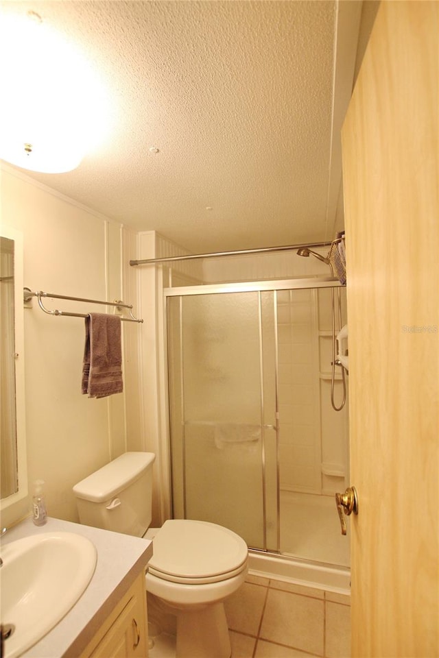 bathroom with toilet, an enclosed shower, tile floors, a textured ceiling, and vanity