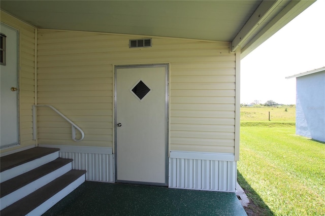 doorway to property featuring a lawn