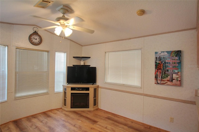 living room with light hardwood / wood-style flooring, ceiling fan, and vaulted ceiling