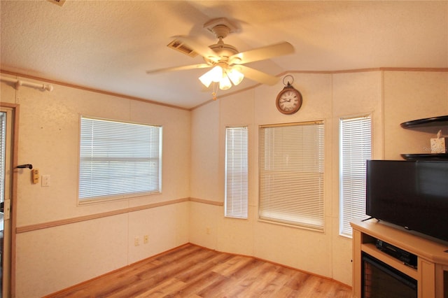 interior space with vaulted ceiling, ceiling fan, light hardwood / wood-style flooring, and a textured ceiling